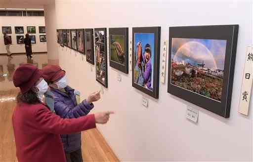 第６２回熊日写真展の作品展が始まり、力作に見入る来館者たち＝２３日午前、熊本市中央区の県立美術館分館（小野宏明）