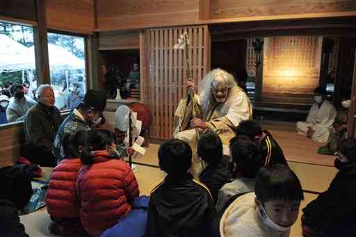 再建された宮山神社の拝殿で奉納された奉納神楽で、子どもたちを脅かす鬼神どん（中央）＝西原村