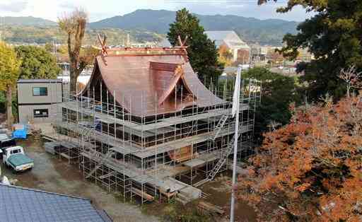 足場の解体が進み、姿を現した木山神宮の神殿。銅板の屋根が夕日を浴びて輝いていた＝２５日午後４時１５分ごろ、益城町（高見伸、小型無人機で撮影）