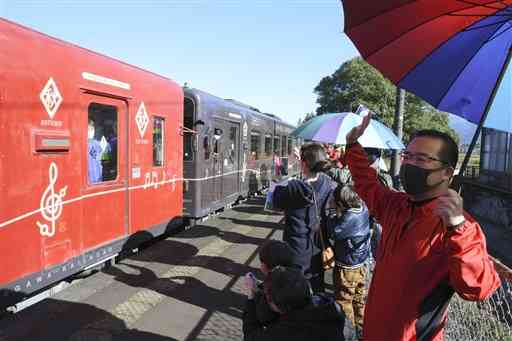 肥後西村駅に到着したくま川鉄道の列車を笑顔で出迎える地元住民ら＝２８日、錦町