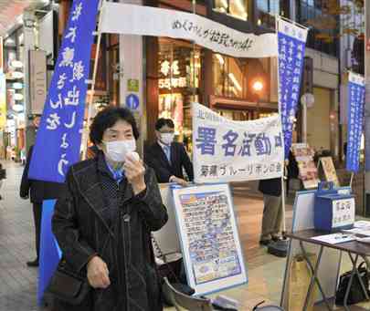 拉致被害者の早期救出に向けて署名を呼び掛ける齊藤文代さん（左）＝１５日、熊本市中央区