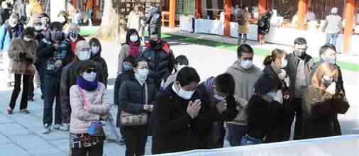 今年の元日、間隔を空けて並び、順番に手を合わせるマスク姿の初詣客＝熊本市中央区の藤崎八旛宮