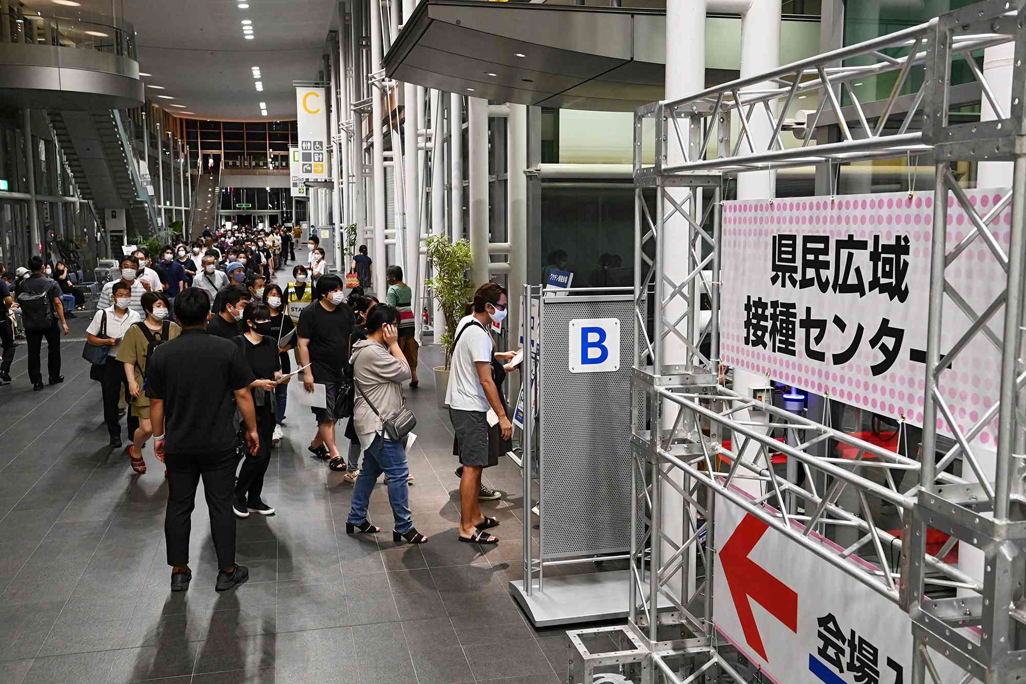 新型コロナウイルスワクチンの大規模接種会場となったグランメッセ熊本。入場口には行列ができた＝８月２日、益城町 