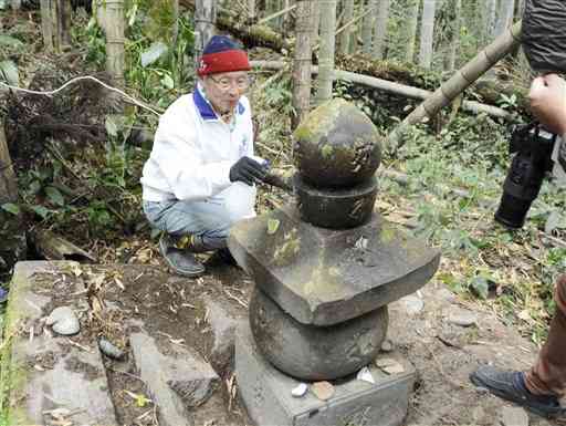 相良清兵衛の母親の墓石を掃除する益田啓三さん＝人吉市