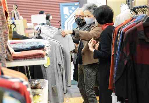 女性客に、商品の特徴を説明する「洋装のタバラ」のスタッフ（右）＝熊本市中央区
