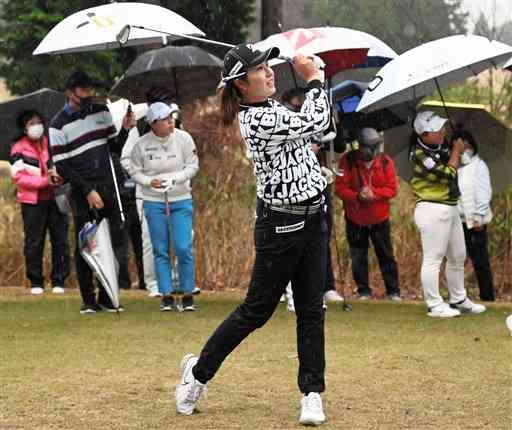 雨が降る中、ティーショットを放つ大里桃子選手＝阿蘇市