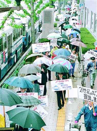 公共交通の利用を進め、地球温暖化を防ごうとパレードで訴える人々＝２０００年４月２１日、熊本市