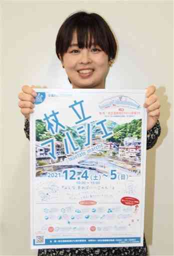 「杖立マルシェ」のポスターを手にする実行委員長の松井美佑紀さん＝小国町