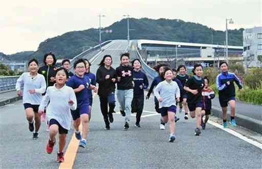 通行止めが続く牛深ハイヤ大橋の車道をダッシュする選手たち＝天草市