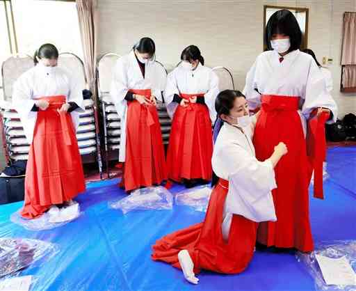 初詣客を迎えるため、巫女の衣装合わせをする高校生ら＝熊本市中央区