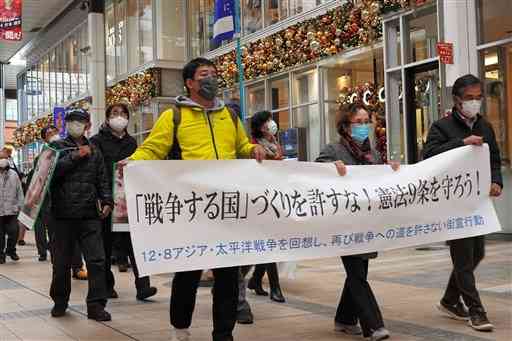 反戦や護憲を訴えデモ行進する市民団体＝８日、熊本市中央区