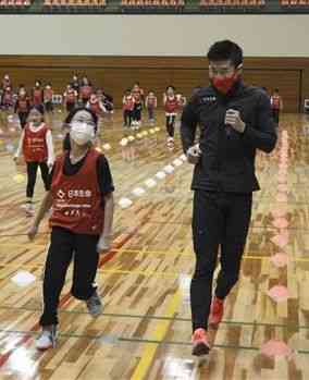 かけっこ教室で小学生と並走する桐生祥秀選手（右）＝熊本市中央区