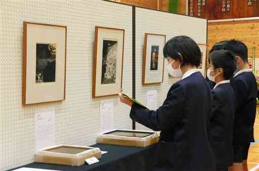 体育館に展示された作品を鑑賞する有明小の児童ら＝天草市