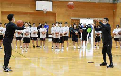 中学生にパスの基本を指導する熊本ヴォルターズの柿内輝心選手（右）と奥田雄伍選手＝大津町