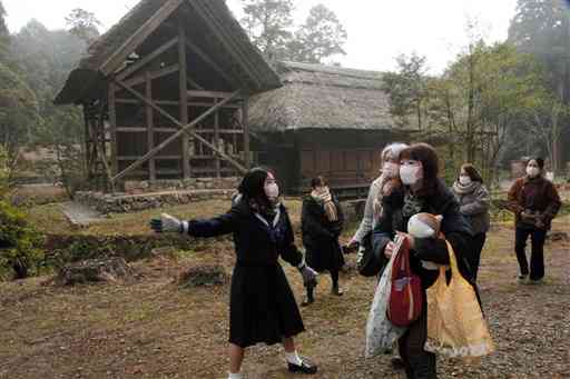 くま川鉄道のモニターツアーで十島菅原神社をガイドする高校生（左）＝相良村