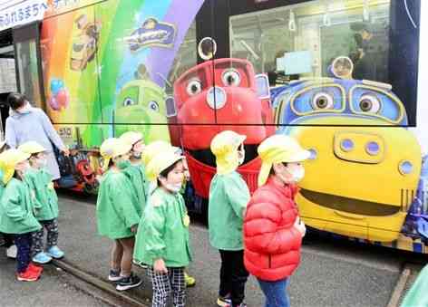 人気鉄道アニメ「チャギントン」のラッピング電車を見て喜ぶみどり幼稚園の園児ら＝熊本市中央区