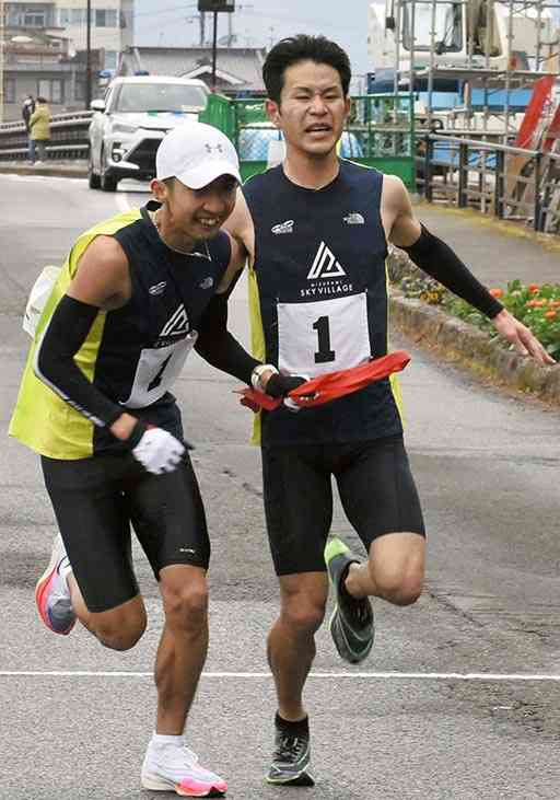 ２区森下選手（右）から３区河野選手にリレーする水上村Ａ＝人吉市（坂本明彦）