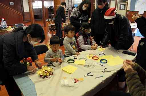 よりあいカフェでクリスマスリース作りを楽しむ参加者＝八代市