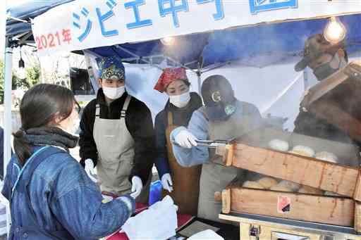 シカ肉を使ったピザまんを販売する八代農高泉分校の生徒ら＝熊本市中央区