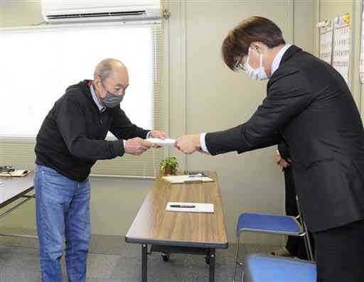 斉藤鉄夫国土交通相宛てに要請書を提出する「瀬戸石ダムを撤去する会」の出水晃共同代表（左）＝２７日、八代市