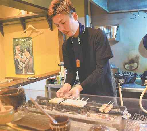 熊本市中心部に１１月開業した焼き鳥店の厨房（ちゅうぼう）に立つ橋口睦さん＝熊本市中央区