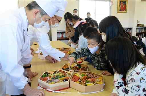 おせち料理を眺める藤崎台童園の子どもたち＝３１日、熊本市中央区