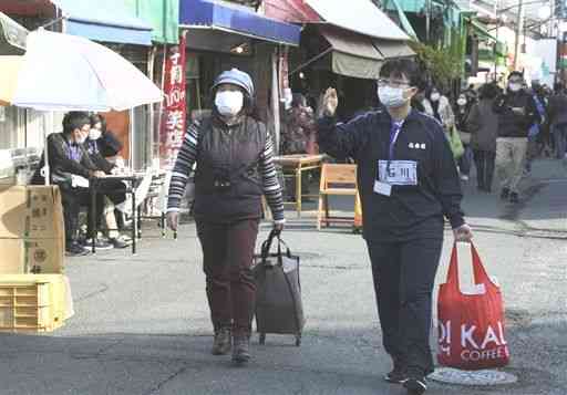 「お困りごと相談会」で、買い物の荷物を運ぶのを手伝う高校生＝熊本市中央区