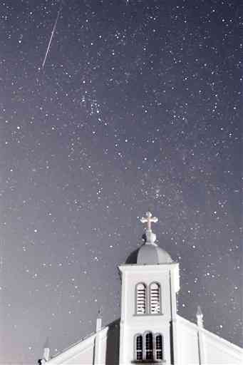 大江教会上空を流れる「ふたご座流星群」の流れ星（左上）＝天草市