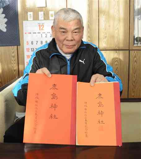 １９７５年に編さんされた鹿島神社の冊子（右）を復刻した永田春生さん。左は新しい冊子＝氷川町