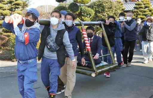 今年厄入りした男性を竹かごに乗せて練り歩く福原地区の住民＝益城町