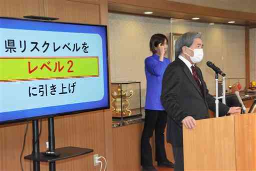 県独自の新型コロナウイルス感染リスクレベルを「２（警戒強化）」に引き上げたと発表する蒲島郁夫知事＝１２日、県庁