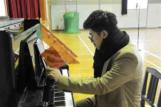 母校の旧松尾西小で楽曲制作に取り組むシンガー・ソングライターの上村翔平さん＝熊本市西区