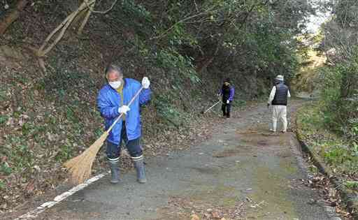 「根引きの子部屋」への山道を清掃する信者や住民ら＝天草市