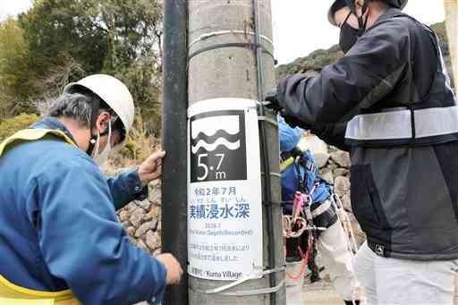 渡地区の電柱に取り付けられた、熊本豪雨による浸水の高さが明記された標識＝球磨村