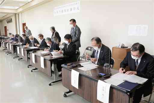 合併に向けて予備契約書に署名する９土地改良区の理事長ら＝熊本市南区