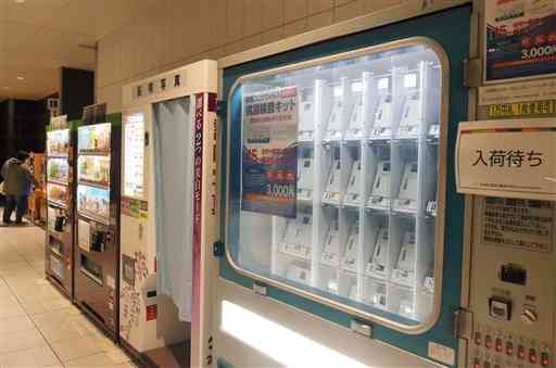 売り切れとなり、「入荷待ち」のステッカーが張られた抗原検査キットの自動販売機＝２８日、熊本市中央区