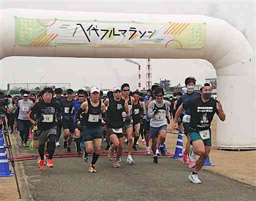 球磨川河川敷スポーツ公園をスタートする八代フルマラソンの参加者＝八代市