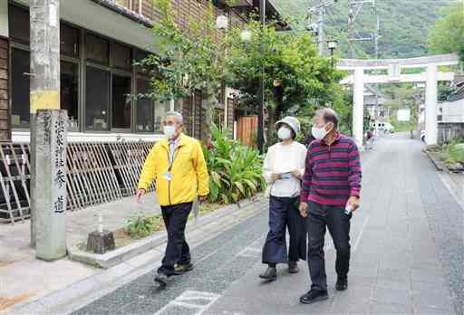 昨年１１月、日奈久地域であったヘルスツーリズムのツアー。ガイドの中村重之さん（左）の案内で、日奈久温泉神社などを巡った＝八代市