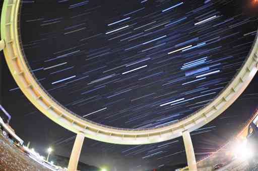 牛深ランプ橋の背後に輝く星の軌跡＝天草市（３０秒露光の９０枚を比較明合成）