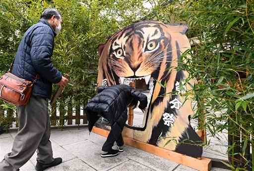 加藤神社の節分祭で、厄よけの虎の口をくぐる参拝者たち＝３日午前、熊本市中央区（石本智）