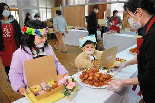 ３００回目を迎えた「エンゼルこども食堂」で、料理を前に笑顔を浮かべる子どもたち＝熊本市西区