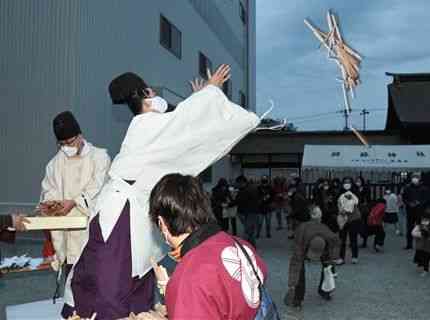 参拝者に向けて護摩木をまく阿蘇神社の神職ら＝阿蘇市