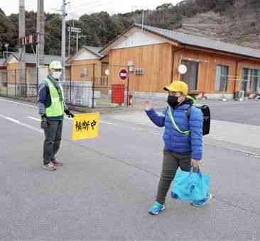 球磨村渡の仮設団地で、スクールバスに向かう児童を見守る東研志さん＝同村