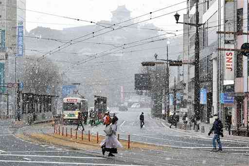 雪が舞う通町筋交差点＝５日午前９時３５分ごろ、熊本市中央区（石本智）