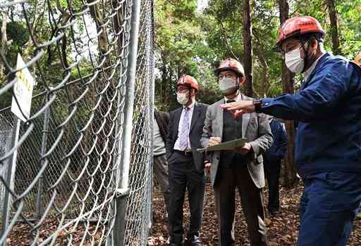 セメントで固めた除草剤の埋設地を視察する田村貴昭衆院議員（右から２人目）ら＝宇土市