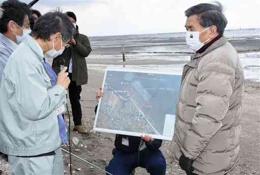 アサリの蓄養場を訪れ、県職員から蓄養作業の流れなどの説明を受ける蒲島郁夫知事（右）＝１６日、玉名市（丸山伸太郎）