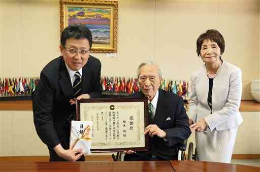 熊本市に１千万円を寄付した柏木明さん（中央）と妻の美智子さん（右）、大西一史市長＝同市役所