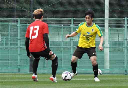 金沢との練習試合でドリブル突破を図る熊本のＭＦ東出壮太（右）＝宮崎市清武総合運動公園