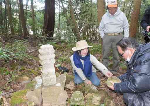 下田城跡にある供養塔や石について、大石一久さん（右）に意見を求める高浜寛さん（左）と松浦四郎さん＝天草市