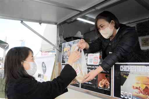 キッチンカーでフライドチキンを販売する「ＷＩＳＨＢＯＮＥ」のリーブス明日香さん＝合志市